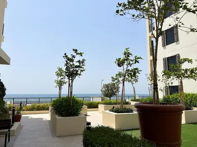 a view of a building with trees and the ocean at NYE Firework View - Beachfront Residence - Sea View in Dubai