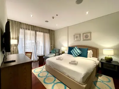 a bedroom with a large bed with a desk and a couch at Specious 1 Br In Royal Amwaj Residences South in Dubai