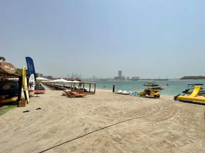 a sandy beach with a group of boats on the water at Specious 1 Br In Royal Amwaj Residences South in Dubai