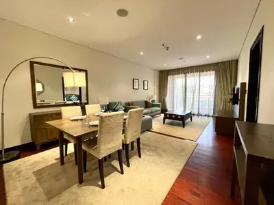 a living room with a dining table and a couch at Specious 1 Br In Royal Amwaj Residences South in Dubai