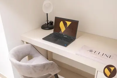 a laptop computer sitting on a desk with a chair at Vogue Downtown Boulevard Point near Burj Khalifa and Dubai Mall, One Bedroom Apartment with Burj Khalifa view from the Balcony and Access to all Amenities in Dubai