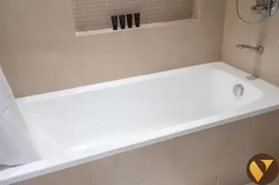 a white bath tub in a bathroom with a sink at Vogue Downtown Boulevard Point near Burj Khalifa and Dubai Mall, One Bedroom Apartment with Burj Khalifa view from the Balcony and Access to all Amenities in Dubai