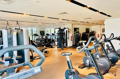 a gym with several treadmills and cardio machines at Vogue Downtown Boulevard Point near Burj Khalifa and Dubai Mall, One Bedroom Apartment with Burj Khalifa view from the Balcony and Access to all Amenities in Dubai