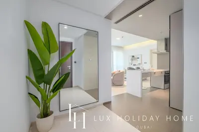 a plant in a living room with a mirror at LUX The West Avenue Dubai Marina Suite in Dubai