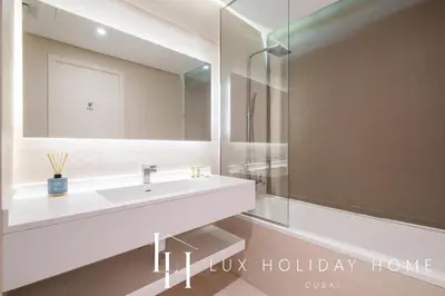 a bathroom with a white sink and a mirror at LUX The West Avenue Dubai Marina Suite in Dubai