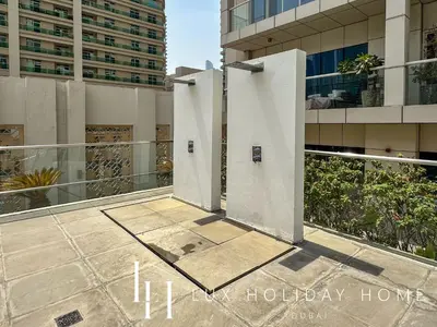 a building with two white pillars on a balcony at LUX The West Avenue Dubai Marina Suite in Dubai