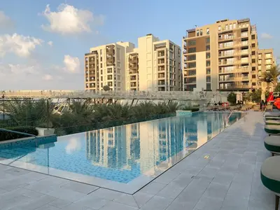 a large swimming pool in a city with tall buildings at FIRST CLASS 2BR Creek Beach Comfort & Style in Dubai