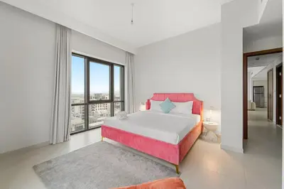 a bedroom with a large bed and a large window at FIRST CLASS 2BR Creek Beach Comfort & Style in Dubai