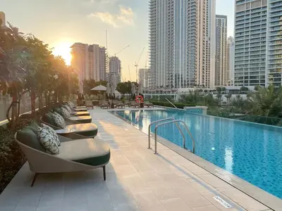 a hotel swimming pool with a row of chairs next to it at FIRST CLASS 2BR Creek Beach Comfort & Style in Dubai