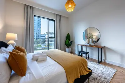 a bedroom with a large bed with a large window at Creek Harbour Serenity with Burj Khalifa Glimpse in Dubai
