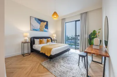a bedroom with a bed and a desk and a window at Creek Harbour Serenity with Burj Khalifa Glimpse in Dubai