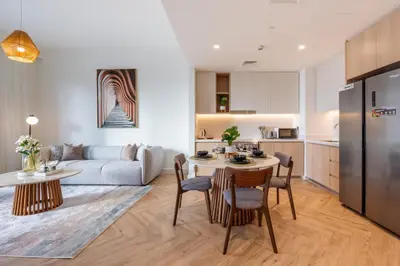 a kitchen and living room with a table and chairs at Creek Harbour Serenity with Burj Khalifa Glimpse in Dubai