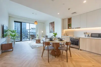 a kitchen and living room with a table and chairs at Creek Harbour Serenity with Burj Khalifa Glimpse in Dubai