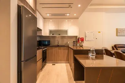 a kitchen with a refrigerator and a counter top at Spacious 2 Bedrooms with maid room I JLT in Dubai