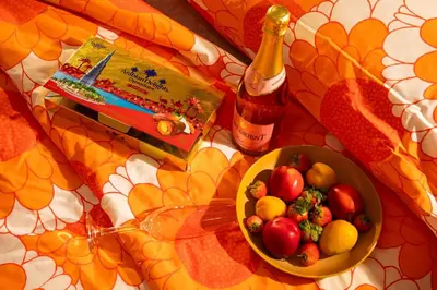 a bowl of fruit and a bottle of wine on a table at Stylish Beachfront Creek Escape in Dubai