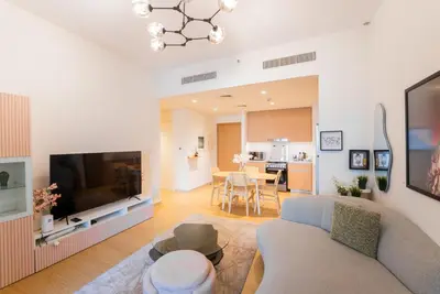 a living room with a couch and a tv at Stylish Beachfront Creek Escape in Dubai