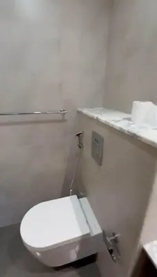 a white toilet in a bathroom with a counter at Plush & Modern 2BR Luxury stay with picturesque Rooftop 64th floor in Dubai