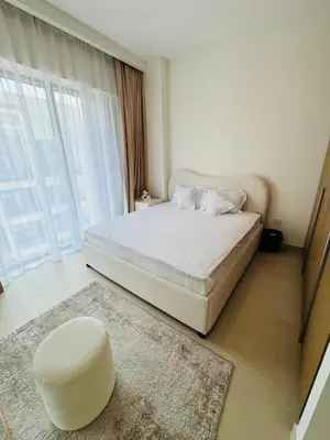 a bedroom with a white bed and a white ottoman at Apartment In Creek Beach in Dubai