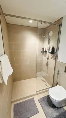 a bathroom with a glass shower with a toilet at Apartment In Creek Beach in Dubai