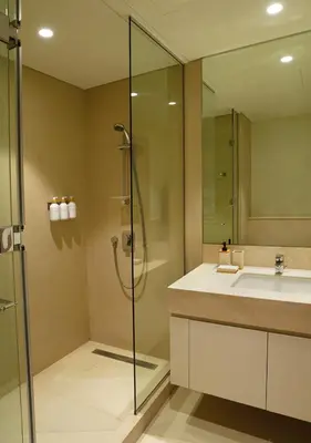 a bathroom with a glass shower and a sink at Chic 2BR in Downtown, 5 Min Walk to Burj Khalifa in Dubai