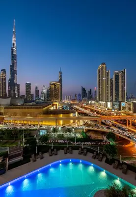 a view of a city at night with a pool at Burj View Direct to Dubai Mall 2BR in Dubai