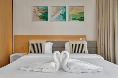 two swans towels sitting on top of a bed at Burj View Direct to Dubai Mall 2BR in Dubai