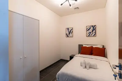 a bedroom with a bed with orange pillows at HAVN - 2 Bedroom Luxe Stay at The Crest, Sobha in Dubai