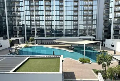 a large swimming pool with a large building in the background at HAVN - 2 Bedroom Luxe Stay at The Crest, Sobha in Dubai