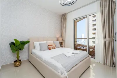 a bedroom with a large bed and a large window at Gala Guests - Serene Lakeside Residences Production City in Dubai