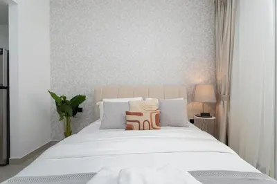 a bedroom with a white bed with two pillows at Gala Guests - Serene Lakeside Residences Production City in Dubai