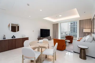 a living room with a couch and a table and chairs at Luxury 1 Bedroom in Emaar Beach Front - Dubai Marina - Private Beach in Dubai