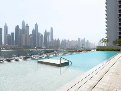 a swimming pool with a city skyline in the background at Luxury 1 Bedroom in Emaar Beach Front - Dubai Marina - Private Beach in Dubai