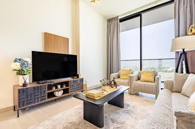 a living room with a large television and a couch at Luxury 1BR in Binghatti Onyx JVC with Pool, Gym & Balcony in Dubai