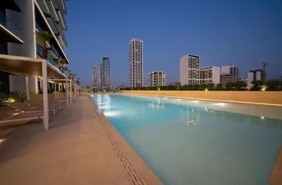 a large swimming pool with a city skyline in the background at Luxury 1BR in Binghatti Onyx JVC with Pool, Gym & Balcony in Dubai