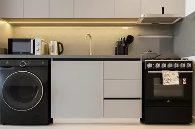 a kitchen with a washing machine and a stove at Stylish Studio 10 Mins from Dubai Mall Meydan Area in Dubai
