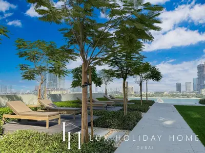 a park with lounge chairs and a tree at LUX The Palace Residence Suite 2 in Dubai