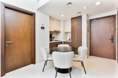 a dining room with a table and white chairs at Luxury 2 Bed with Iconic Burj View, Near Dubai Mall in Dubai