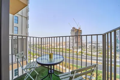a balcony with a table and chairs and a view of the city at Modern 1BR at Collective Dubai Hills Mall Nearby in Dubai