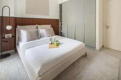 a bedroom with a large white bed with a table at Frank Porter - Bayshore at Creek Beach Building 4 in Dubai