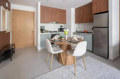 a kitchen with a wooden table and white chairs at Frank Porter - Bayshore at Creek Beach Building 4 in Dubai