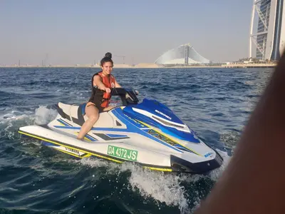 a woman riding a jet ski in the water at A one sports jetski rental in Dubai