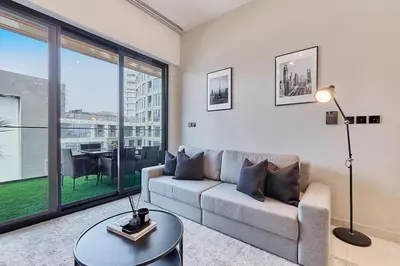 a living room with a couch and a table at Water Dream with Burj Views Sleeps 4 in Dubai