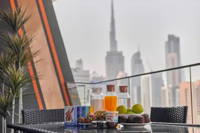 a table with fruit and juice on a balcony at Water Dream with Burj Views Sleeps 4 in Dubai