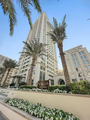 a large building with palm trees in front of it at FIRST CLAS 1BR Creek Beach , Lagoon Access in Dubai