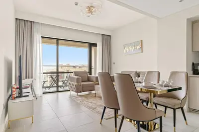a living room with a table and chairs and a television at FIRST CLAS 1BR Creek Beach , Lagoon Access in Dubai
