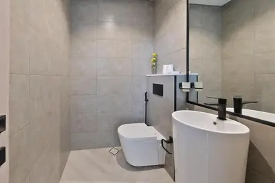 a bathroom with a white toilet and a sink at Bright & Stylish 1-Bedroom at Empire Residence in Dubai