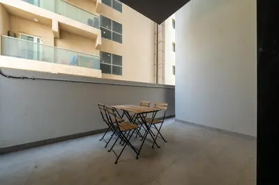 a table and chairs in a room with a building at Bright & Stylish 1-Bedroom at Empire Residence in Dubai