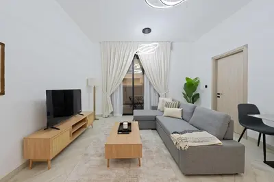 a living room with a couch and a tv at Bright & Stylish 1-Bedroom at Empire Residence in Dubai