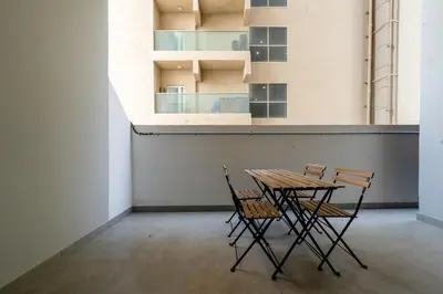 two chairs and a table in an empty room at Bright & Stylish 1-Bedroom at Empire Residence in Dubai