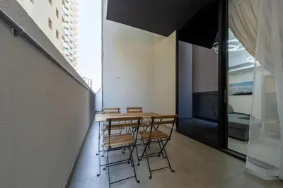 a table and chairs in a room with a window at Bright & Stylish 1-Bedroom at Empire Residence in Dubai